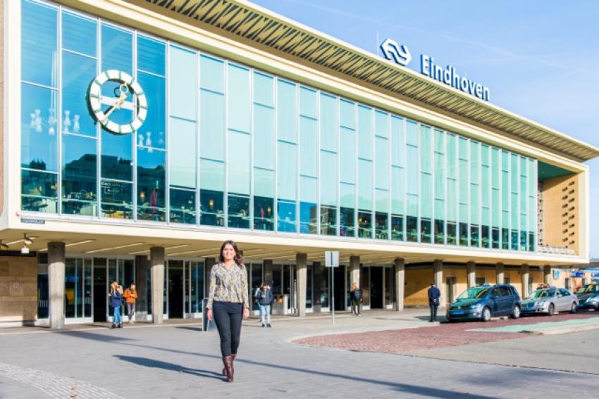 beeld van een collega lopend voor het NS station in eindhoven