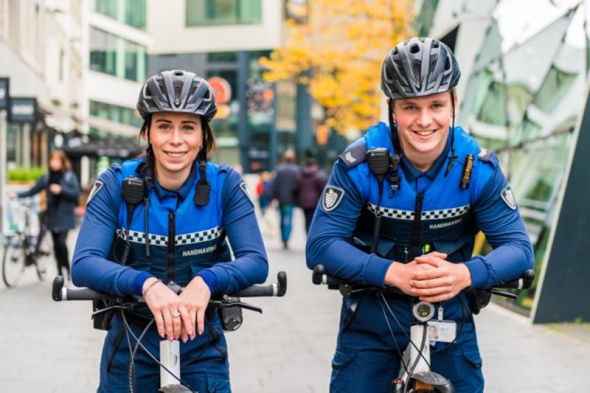 afbeelding van 2 handhavers leunend op de mountainbike