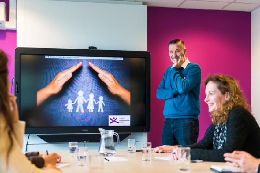 Collega staand voor een groot digitaal scherm van de gemeente Eindhoven