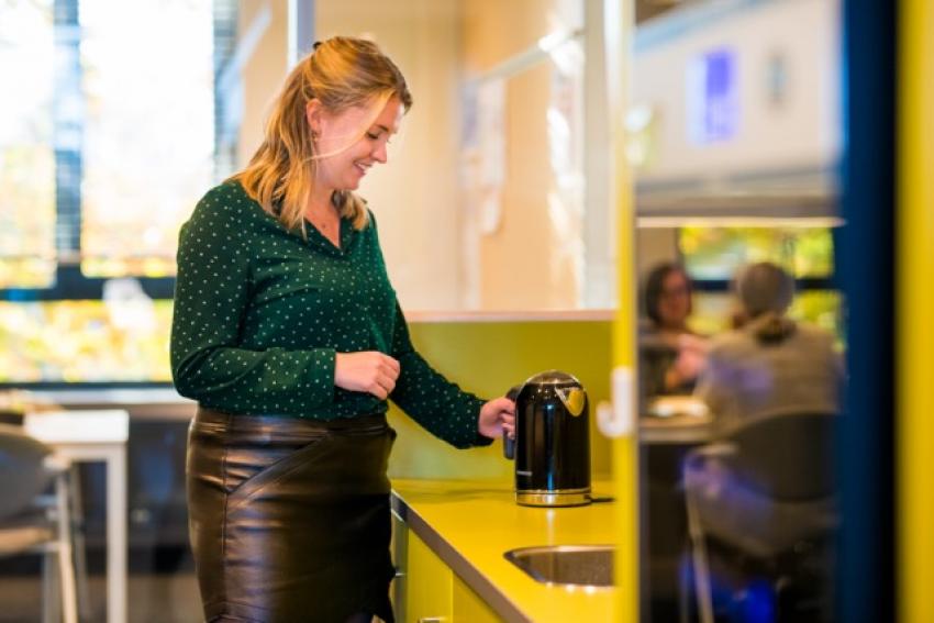afbeelding van collega in het keukentje, zet een kop thee