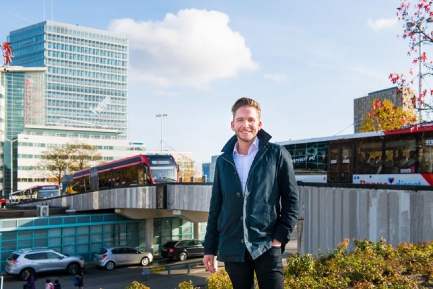 Beeld van een collega met de op de achtergrond het station