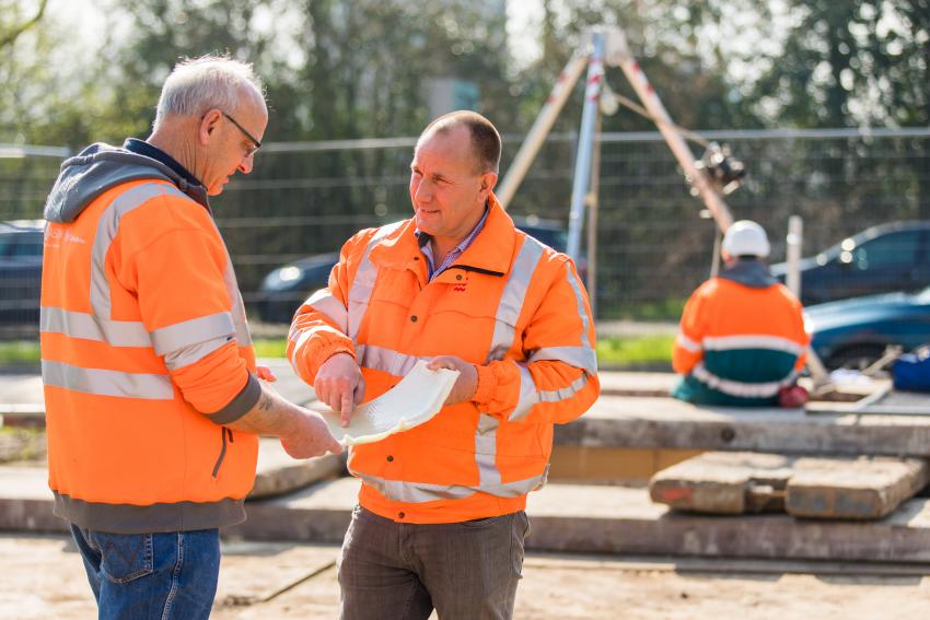Foto van collega in overleg bij het riool