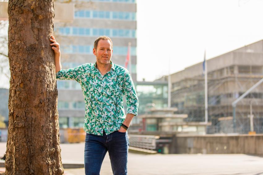 Collega leunend tegen een boom van de gemeente Eindhoven