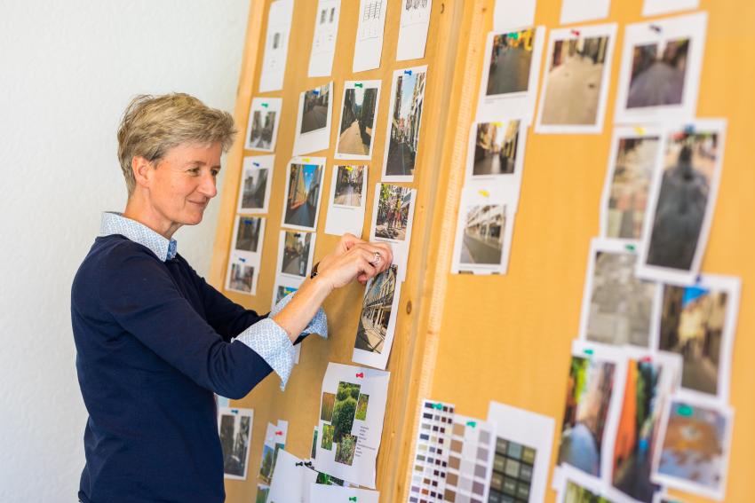 Collega bij een bord vol met foto's