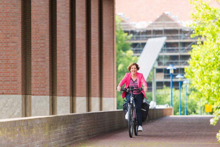 collega van de gemeente Eindhoven fietsend naar het werk