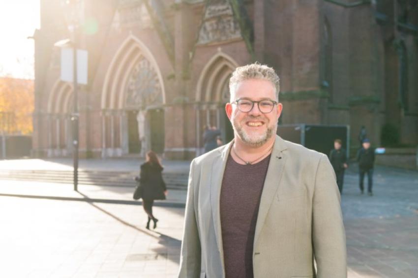 Een lachende collega voor de Catharinakerk van Eindhoven